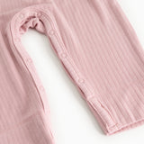 Pink baby jumpsuit with long sleeves and snap button closure at the leg opening.