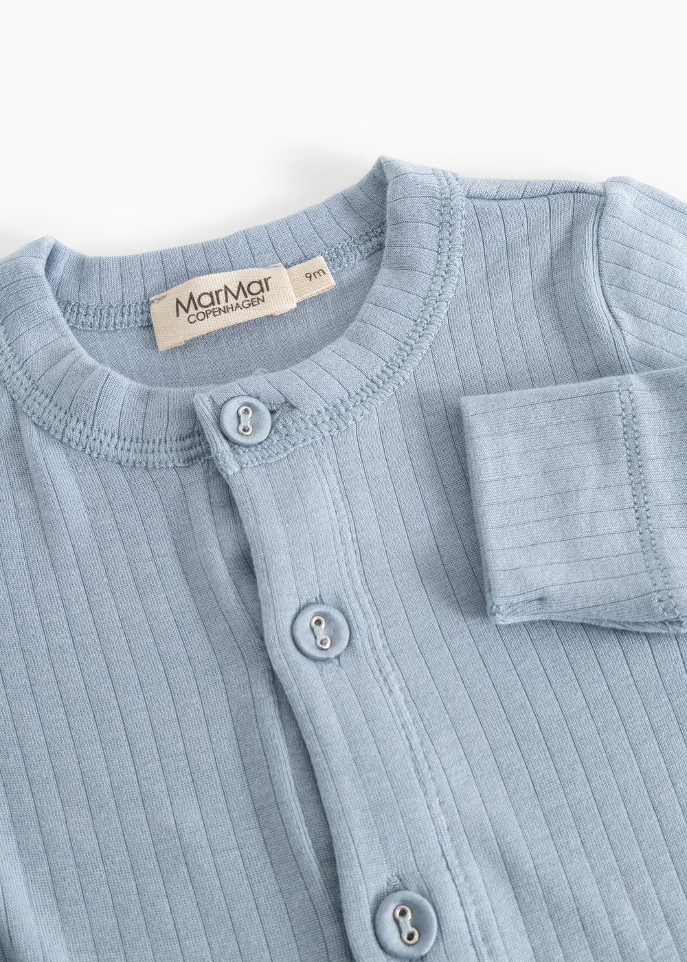 Light blue jumpsuit with front button closure and long sleeves.