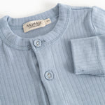 Light blue jumpsuit with front button closure and long sleeves.