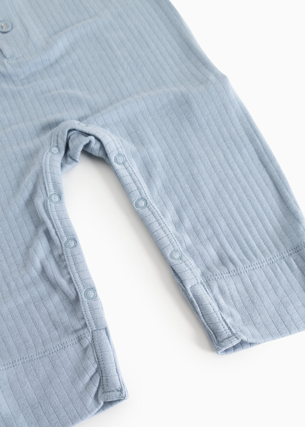 Light blue jumpsuit with buttons at the leg openings and short straps.