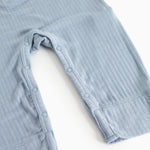 Light blue jumpsuit with buttons at the leg openings and short straps.