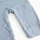 Light blue jumpsuit with buttons at the leg openings and short straps.