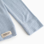 Light blue ribbed long-sleeve T-shirt with button closure and brand label at the edge.
