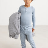 Light blue long leggings for children, ribbed fabric and front snap closure.
