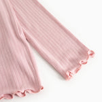 Pink ribbed long-sleeve T-shirt with a creased edge at the sleeve.