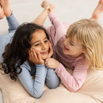 Pink leggings for kids, ribbed fabric and elastic waistband visible under the leg.