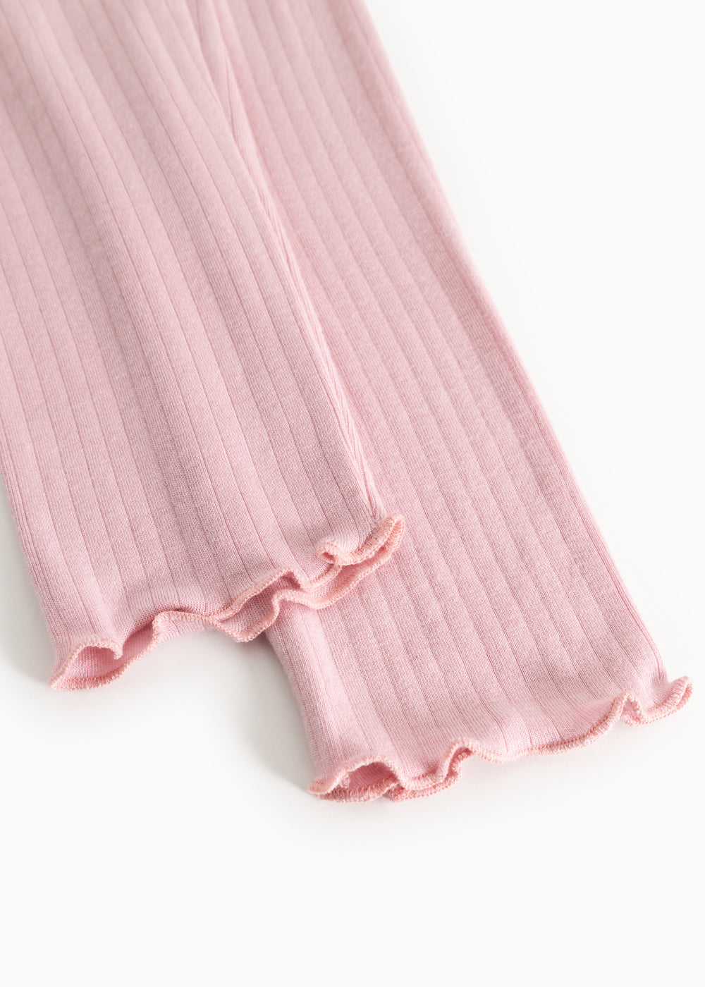Pink leggings with ribbed knit and fringe edge at the ankle, elastic and lightweight drape.