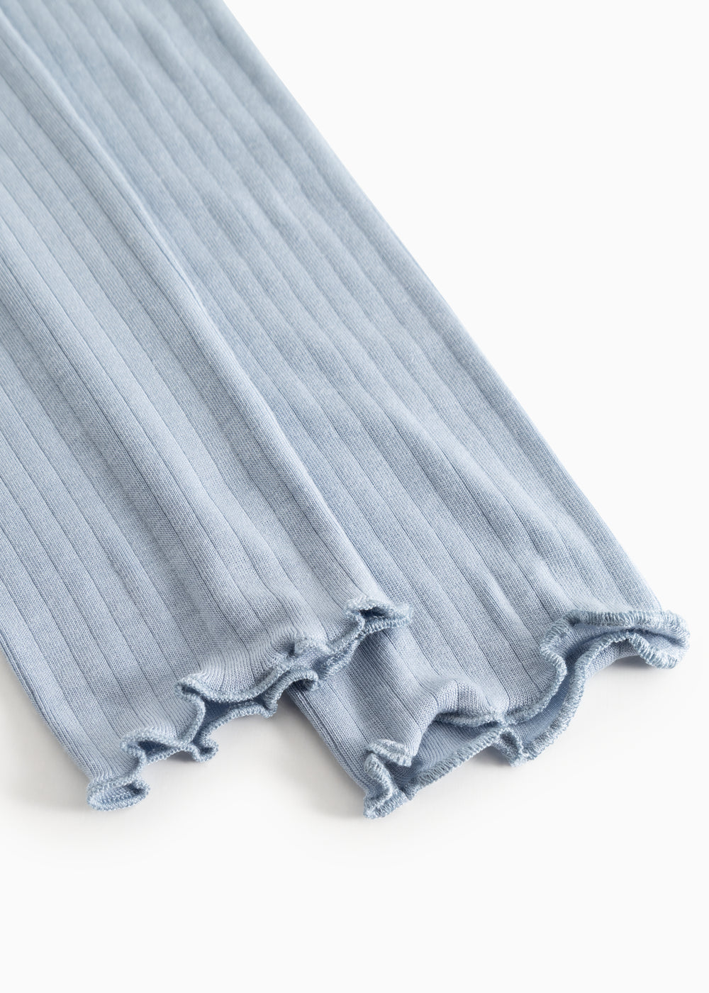 Light blue leggings with ribbed edge and fringe hem.