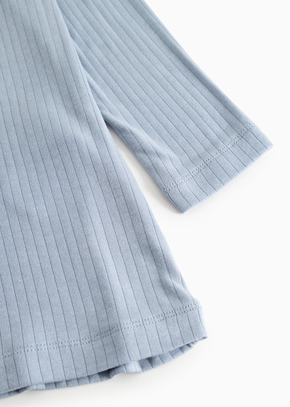 Blue evening dress with ribbed texture and round neckline, visible hem.
