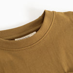 Caramel brown blouse with round neckline and visible seam at the collar