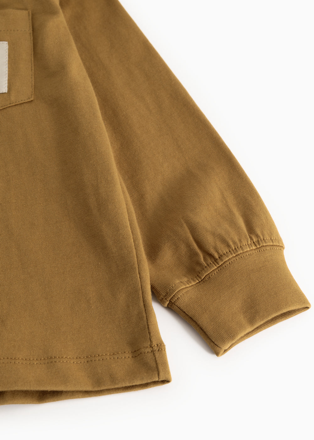 Caramel brown long-sleeve blouse with elastic cuffs and seam at the bottom.