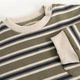 The strap is made of ribbed knit with a snap button at the neckline, as well as ripped cuffs.