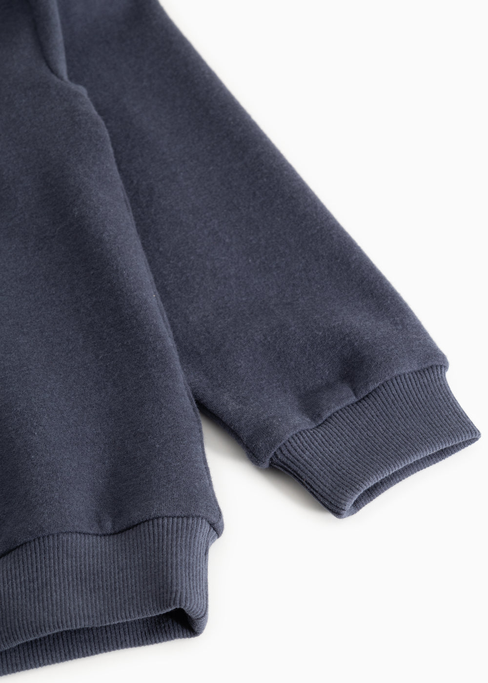 Navy blue sleeve with ribbed cuff at the wrist.