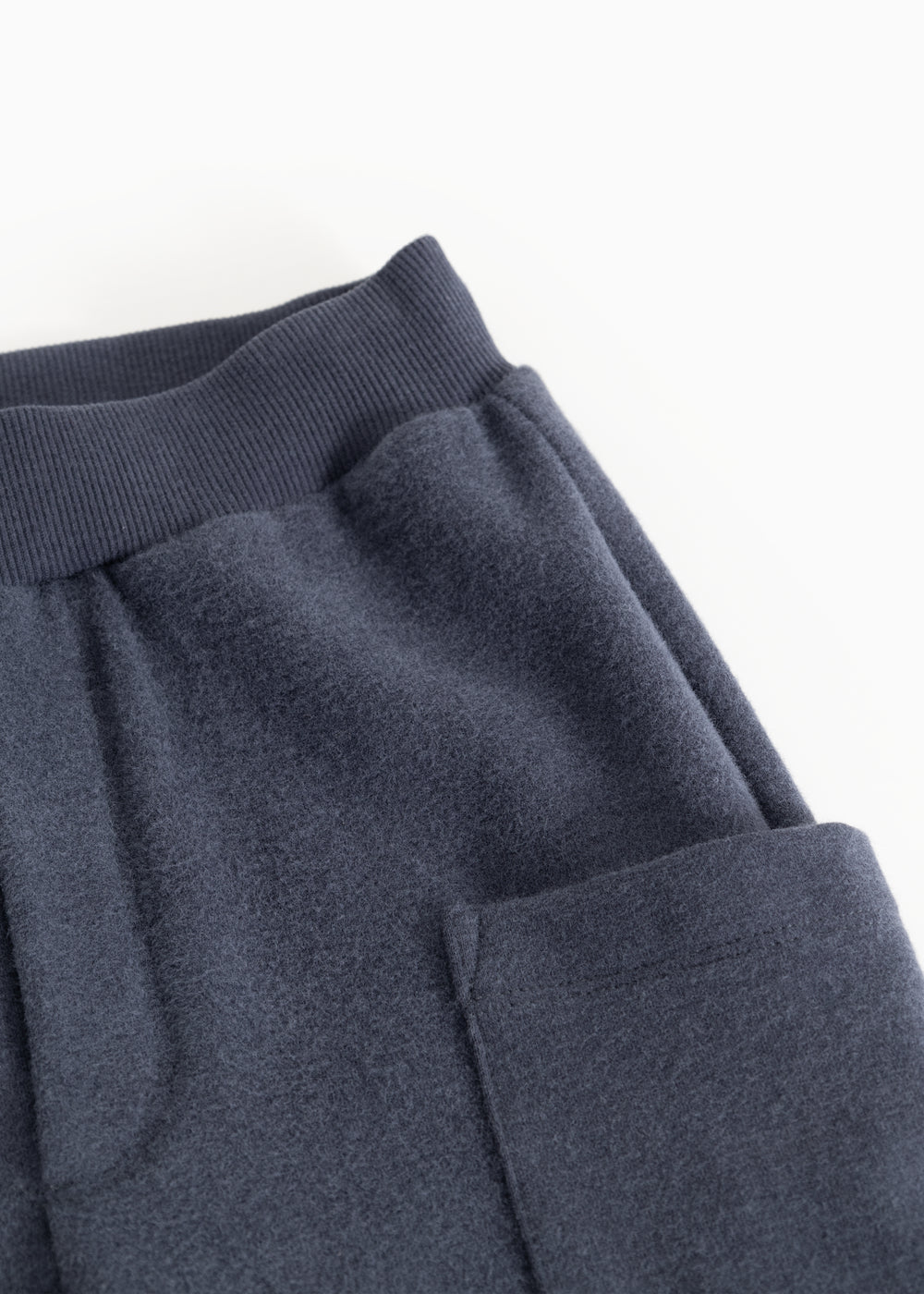 Blue denim kids' pants with a wide elastic waistband and cargo pockets.