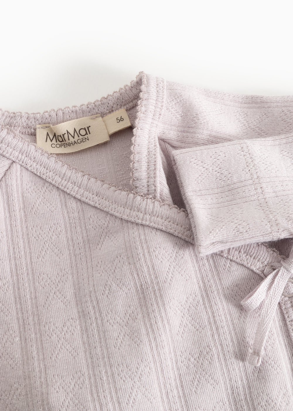 Long-sleeve blouse with a brand label at the collar, elastic edges and a decorative bow.