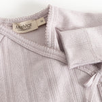 Long-sleeve blouse with a brand label at the collar, elastic edges and a decorative bow.