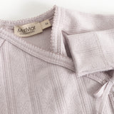 Long-sleeve blouse with a brand label at the collar, elastic edges and a decorative bow.