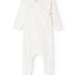 Baby romper in cream white with button closure in front and long sleeves.