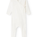 Baby romper in cream white with button closure in front and long sleeves.