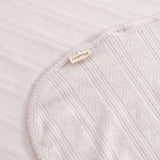 Light pink corner rug with woven pattern, border tape, and sewn-in label.