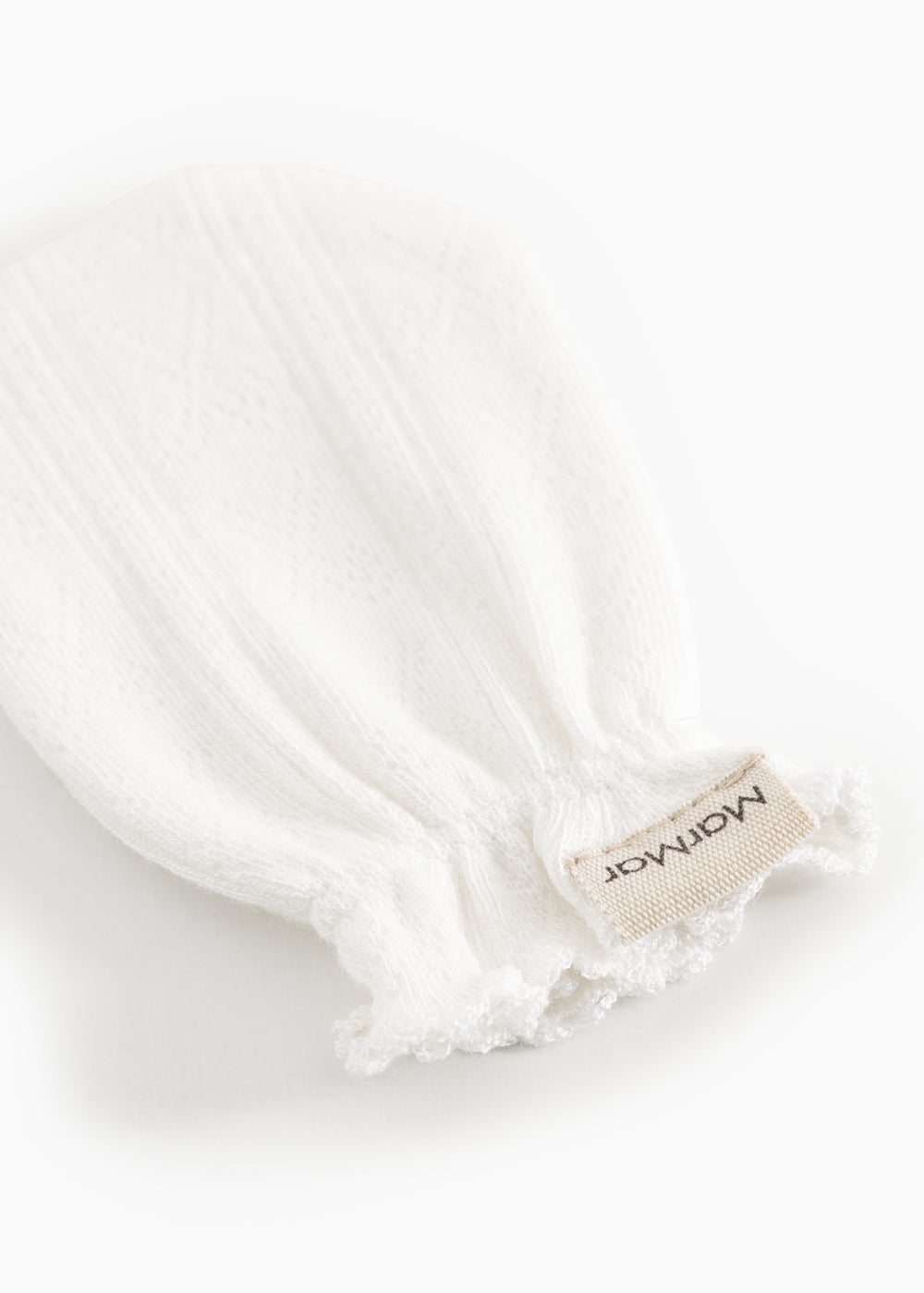 White cuff without fingers with textile label and fringe edges at the wrist.