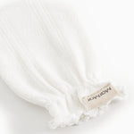 White cuff without fingers with textile label and fringe edges at the wrist.