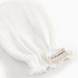 White cuff without fingers with textile label and fringe edges at the wrist.