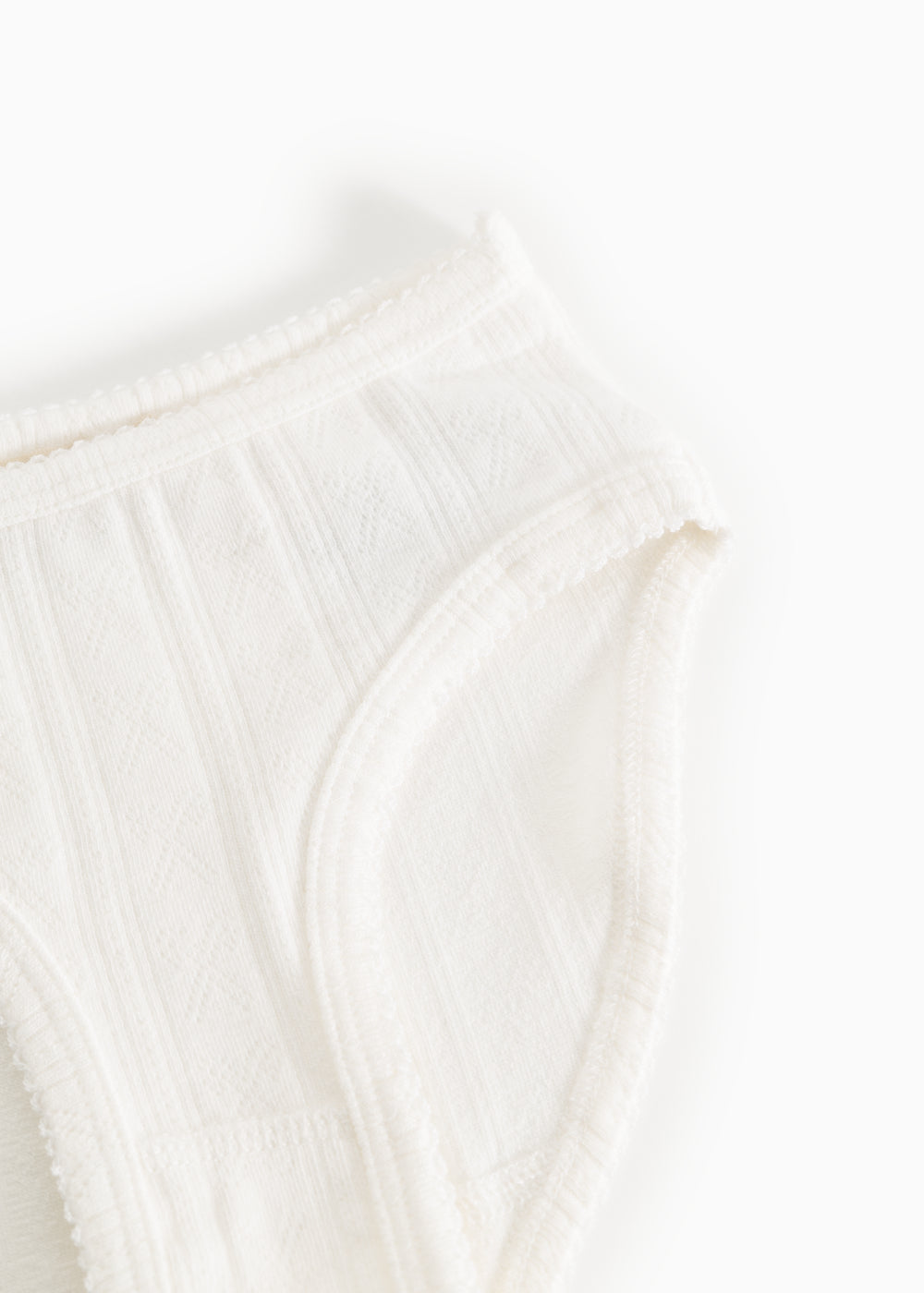 White baby onesies with wide elastic and subtle rib pattern in front.