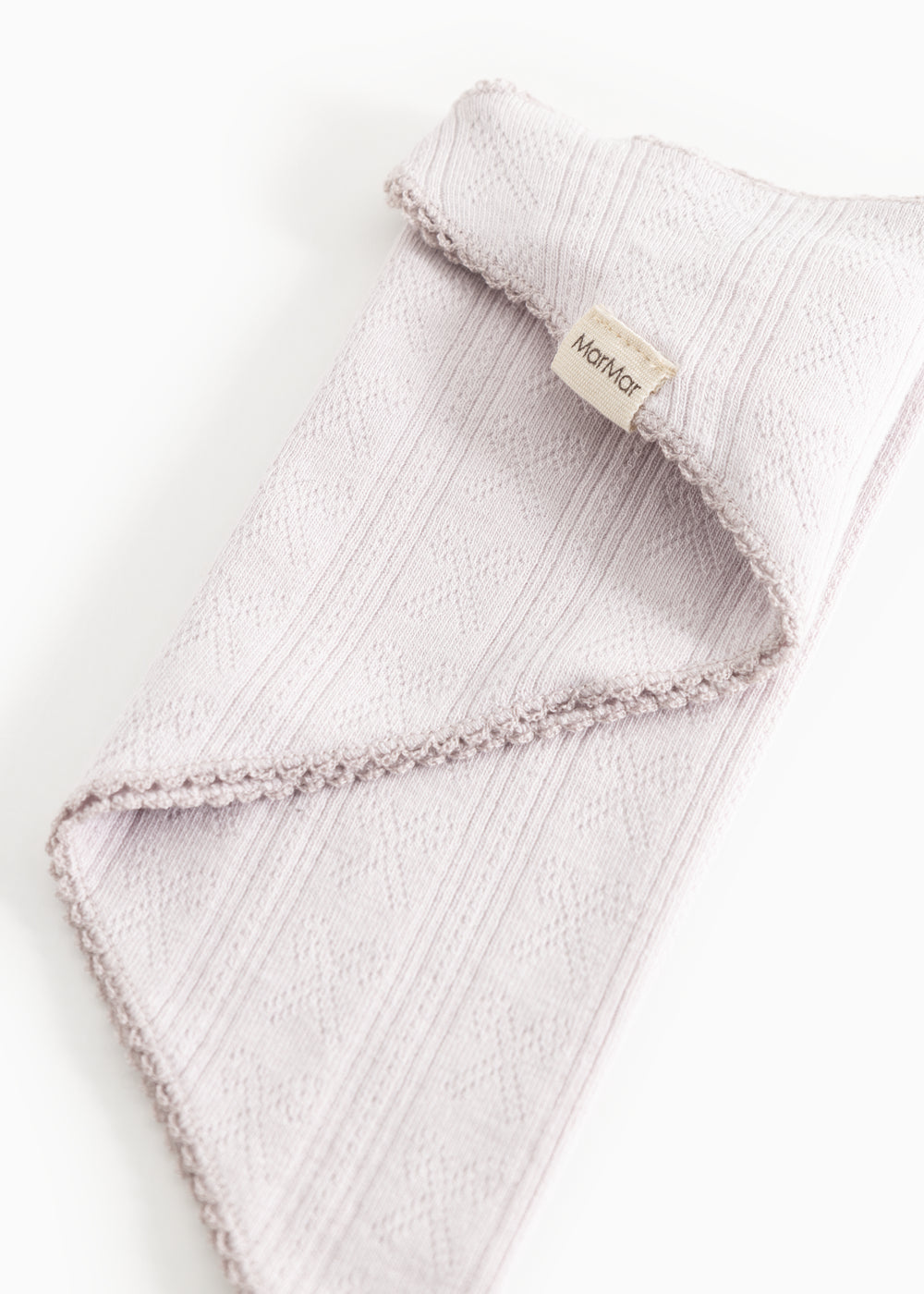 Light pink scarf with fringe edge and texture, label on the fold.
