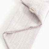 Light pink scarf with fringe edge and texture, label on the fold.