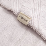 Light pink scarf with fringe edge and woven pattern, detail with brand.