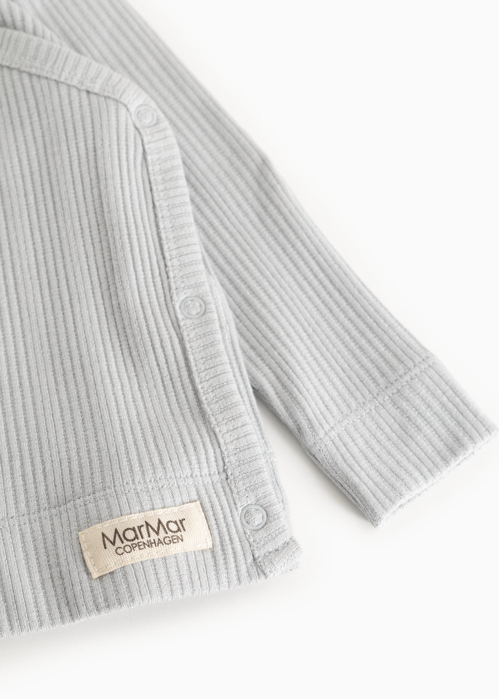 Light gray ribbed blouse with long sleeves and a snap button at the opening.