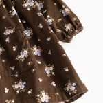 Floral dress in dark brown fabric with small multicolored flowers and a ribbed edge at the sleeve hem.