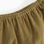 Dark bronze baby pants with elastic waist and pleated lining.