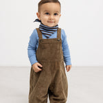 Riri B trousers in dark brown velvet‑ribbed fabric with front pockets and suspenders.