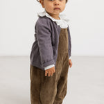 Baby bodystocking with small black dots and a bacon edge, visible at the neck and upper part.