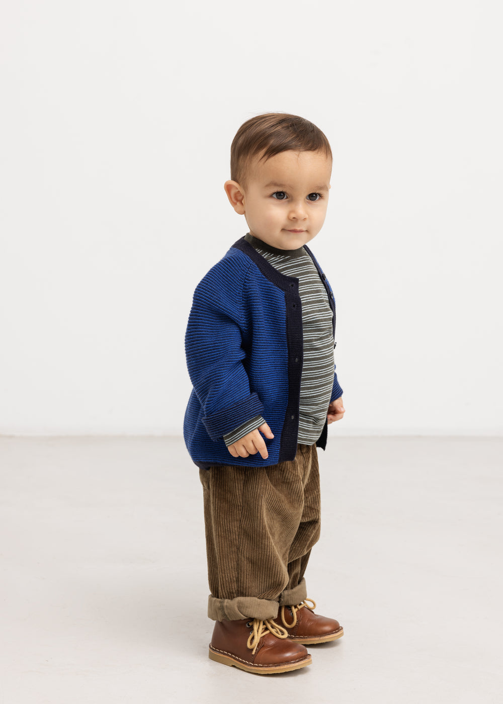 Baby bodysuits in dark brown velvet with elastic at the waist and loose legs.
