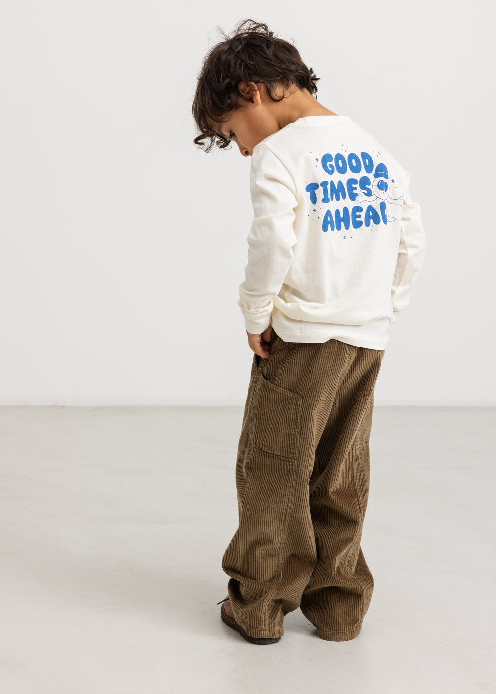 Long-sleeve blouse in cream with a blue "Good Times Ahead" print on the back.