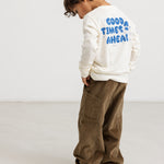 Long-sleeve blouse in cream with a blue "Good Times Ahead" print on the back.