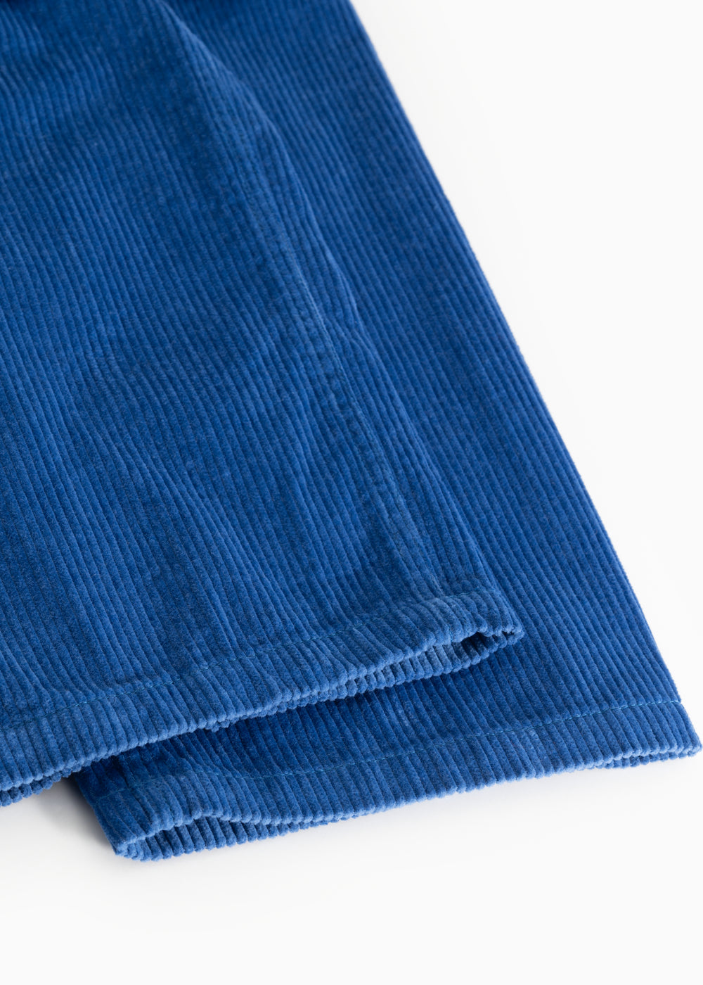 Blue corduroy trousers with visible ribbing and a raised edge at the hem.