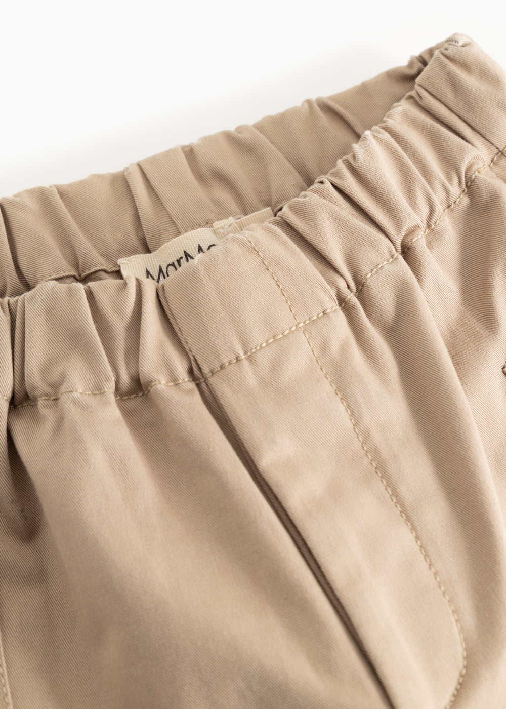 Polle pants in mud-colored beige, elastic at the waist and visible stitching.