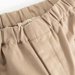 Polle pants in mud-colored beige, elastic at the waist and visible stitching.