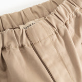 Polle pants in mud-colored beige, elastic at the waist and visible stitching.