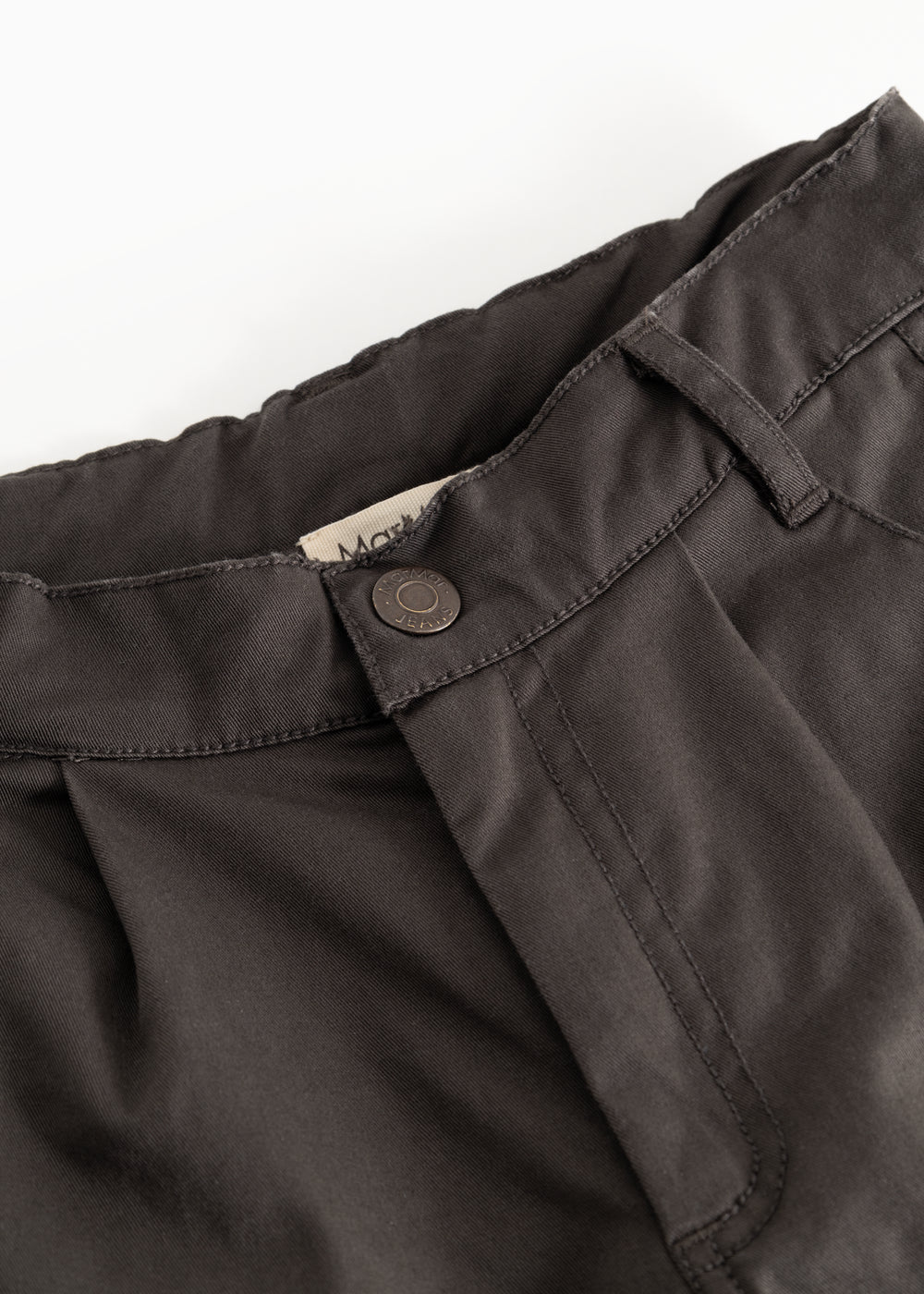 Dark trousers with belt straps and a round button closure at the waist.