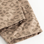 Pants with a warm leo print in light brown, visible seam and hem.