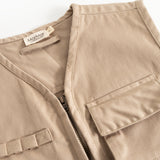 Beige children's vest with V-neck, zipper and flap pockets, and inner label.