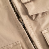 Sand-colored children's vest with a strong black zipper and visible seams.
