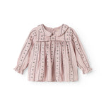 Pink baby blouse with button closure, ruffled details, and long sleeves.