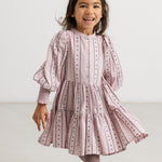 A dress in dusty lilac with a pleated skirt, puff sleeves, and floral details.