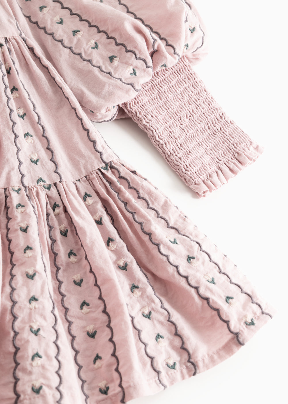 Dress the dress in dusty lilac with floral embroidery and long puff sleeves.